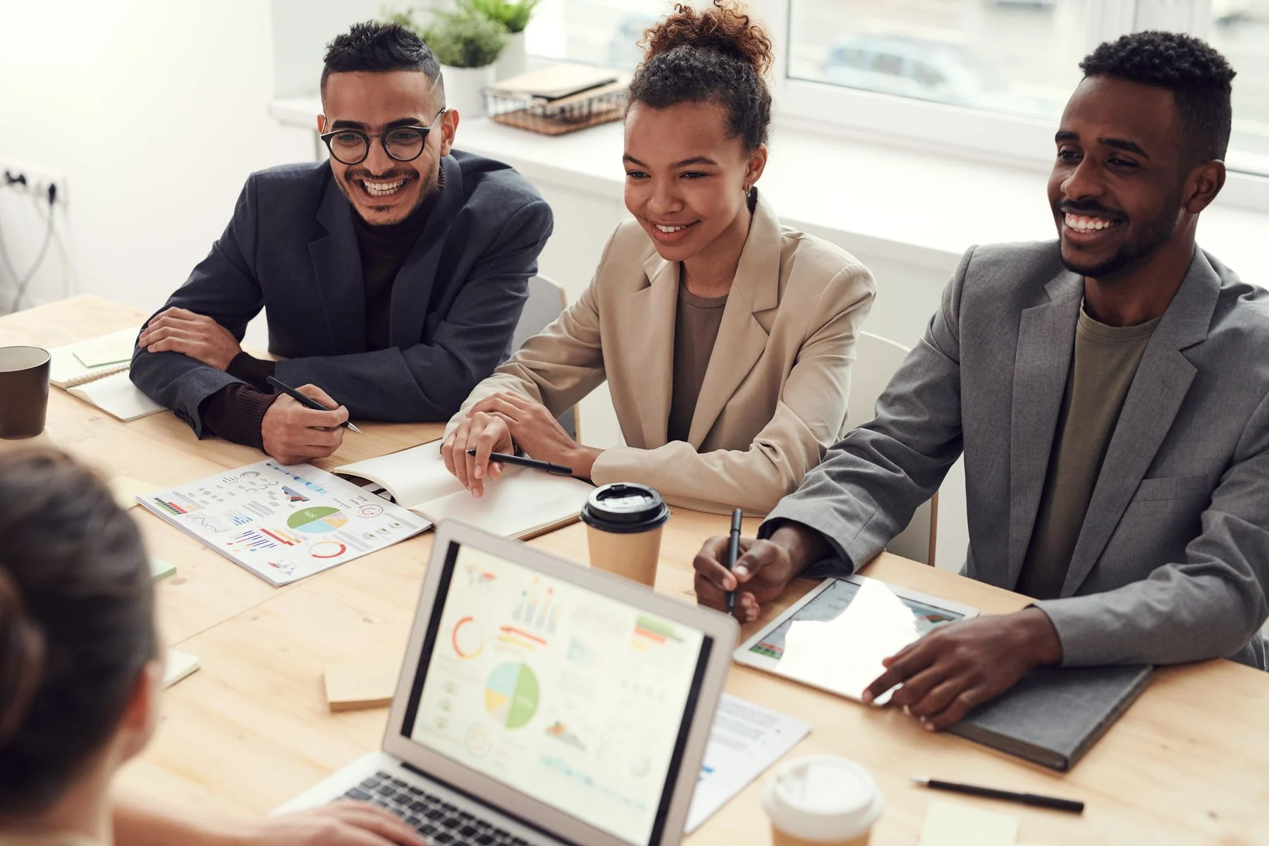Profissionais em uma conversa de negócios, analisando necessidades e possibilidades à mesa.